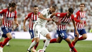 Benzema y jugadores del Atlético de Madrid disputan un balón