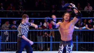 Johnny Impact festeja con el título en el centro del ring