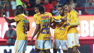 Jugadores de Tigres se abrazan tras una anotación en la Liga MX 