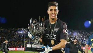 Esteban Andrada sostiene un trofeo que ganó con Boca Juniors