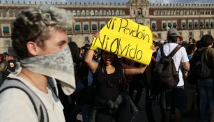 Mujer con un letrero en el Zócalo de la CDMX