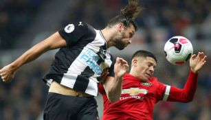 Andy Caroll y Marcos Rojo disputando un balón 