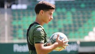 Diego Lainez sujeta con las manos un balón