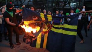 Las manifestantes queman la bandera del América