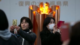 Japoneses se toman selfies con la llama olímpica