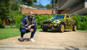 Dani Alves posando con su auto en venta