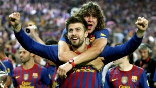 Carles Puyol abraza a Gerard Piqué durante la celebración de un título con el Barcelona