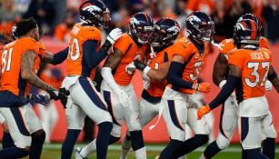 Defensiva de los Broncos festejando una intercepción de Patrick Surtain II