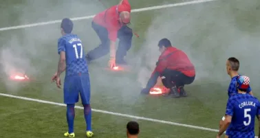 Personal del Staff de la Euro recoge bengalas arrojadas por aficionados