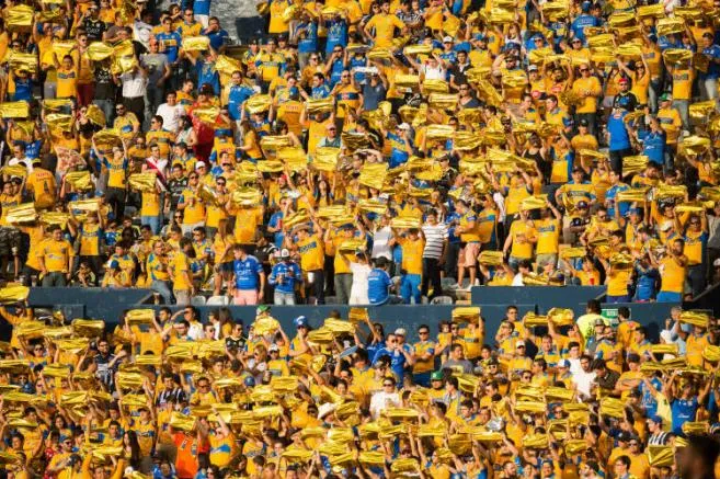 Afición de Tigres muestran un papael dorado para poner color a la tribuna