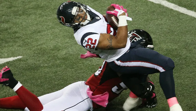 AP Chris Polk es tackleado contra Atlanta