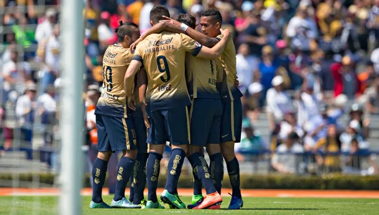 Jugadores de Pumas se felicitan tras un gol