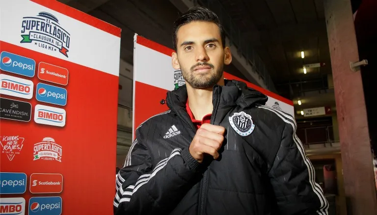 IMAGO7 Dedos López señala el escudo de Chivas