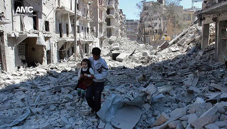 AP Un hombre sirio sostiene a una niña en medio de los escombros de las casas destruidas por un bombardeo