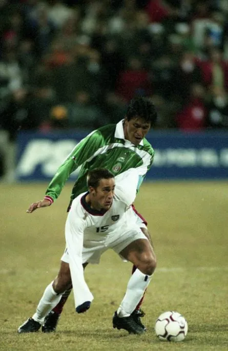 Josh Wolff defendiendo el esférico ante la marca de Claudio Suárez