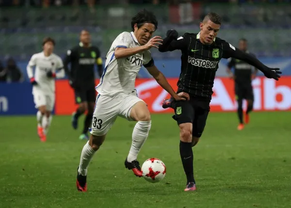 Mateus Uribe de Atlético Nacional peleando un balón con un jugador del Kashima Antlers