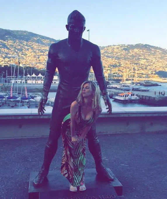 Gente tomándose fotos con el 'paquete' de la estatua