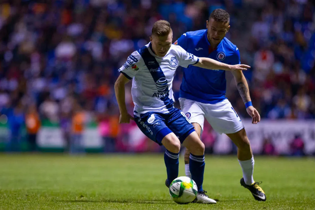 Jugadores de Cruz Azul y Puebla disputan un balón