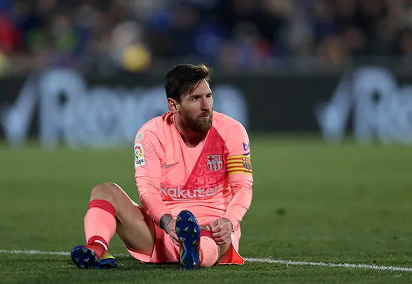 AP Messi, sentado en el césped durante un partido del Barcelona
