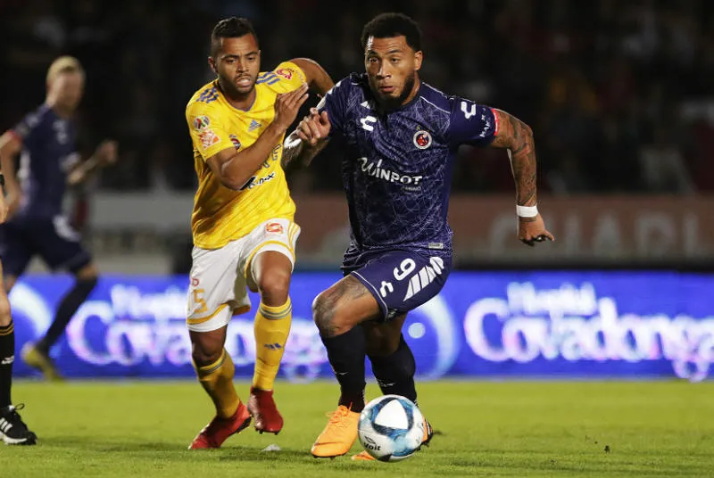 Jugadores de Tigres y Veracruz disputan un balón