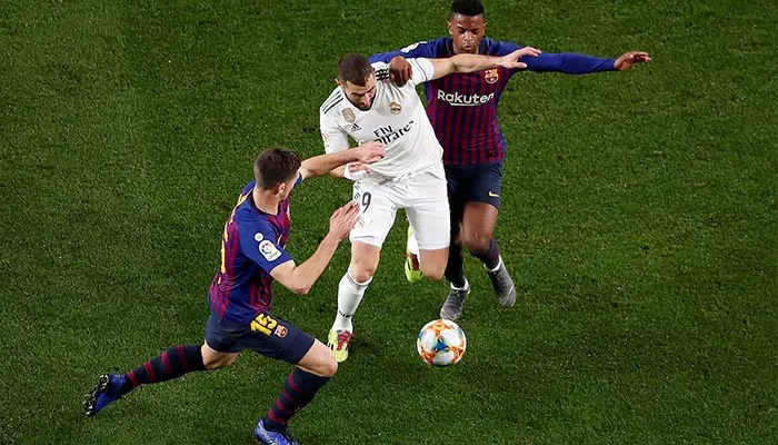Benzema disputando el balón contra el Barcelona