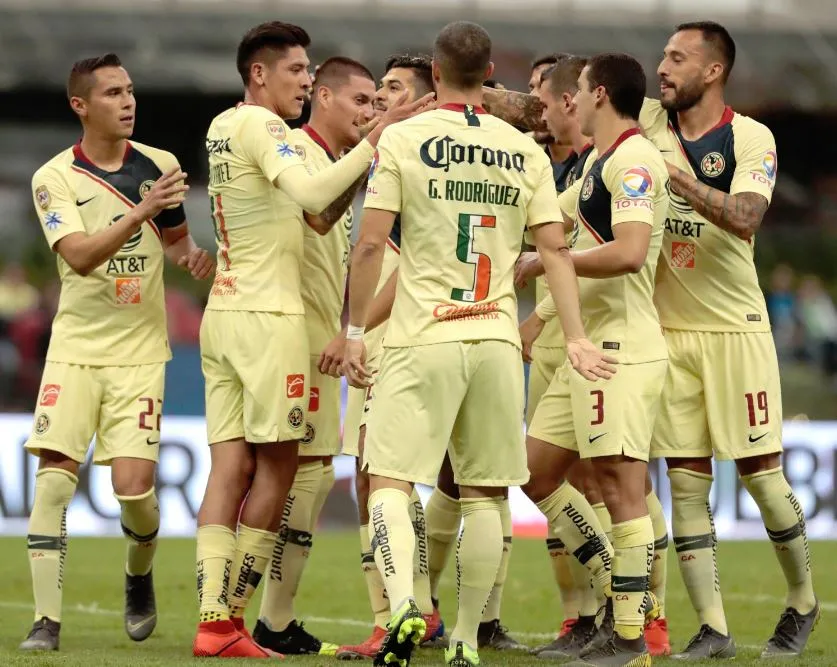 Jugadores de las Águilas festejan anotación contra Lobos