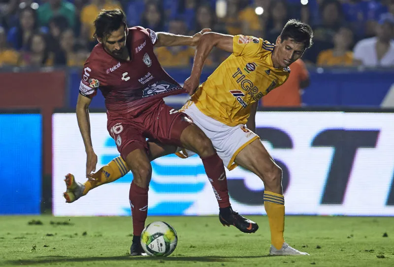 Burrito Hernández y Jürgen Damm disputan un balón