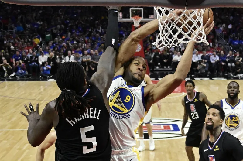 Andre Iguodala intenta encestar sobre Montrezl Harrell