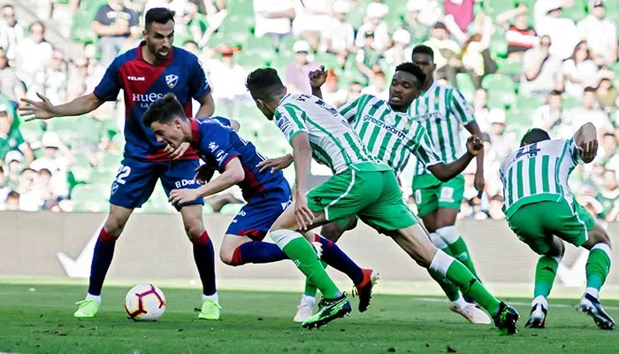 Jugadores del Betis y del Huesca en disputa por el balón