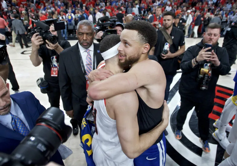 AP Seth y Steph Curry se abrazan al final del partido