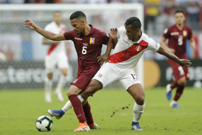 Jugadores de Venezuela y Perú en disputa por el balón