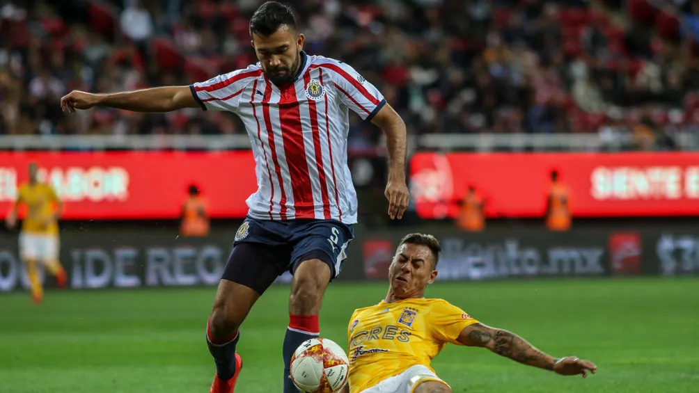 Hedgardo Marín en la disputa del balón en un partido ante Tigres