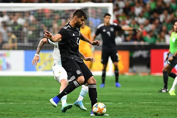 Néstor Araujo disputa el balón en el partido contra Argentina