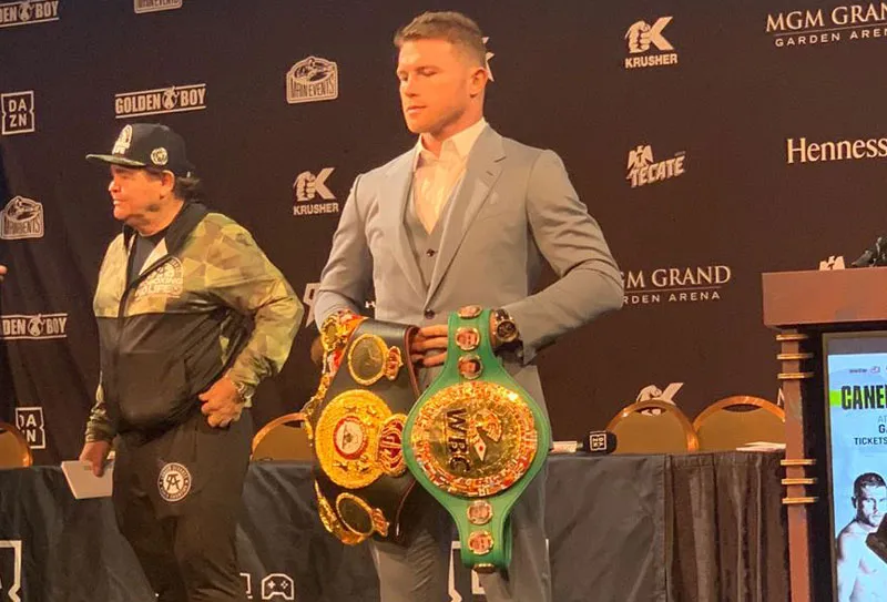 Canelo posa con sus cinturones de campeón mundial