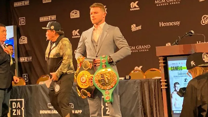 Canelo posa con sus cinturones de campeón mundial
