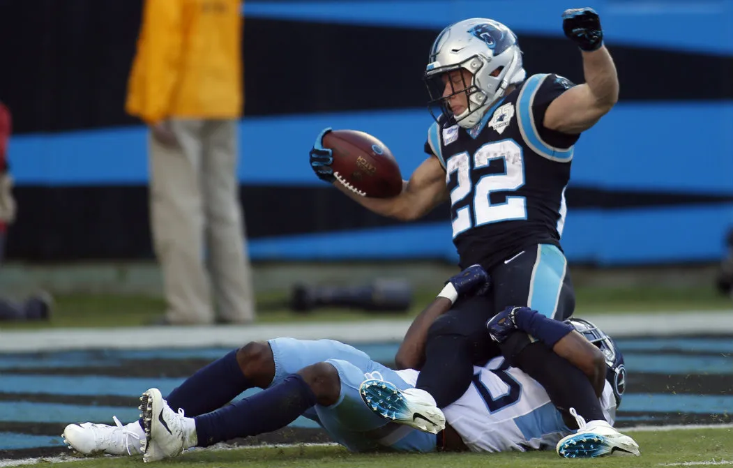 AP Christian McCaffrey anotando frente a Adoree Jackson, de los Titans
