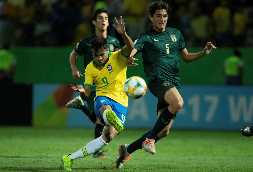 Pedro Lucas de Brasil peleando un balón con Christian Dalle Mura de Italia
