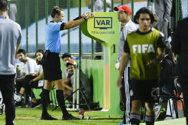 El silbante central revisando la jugada