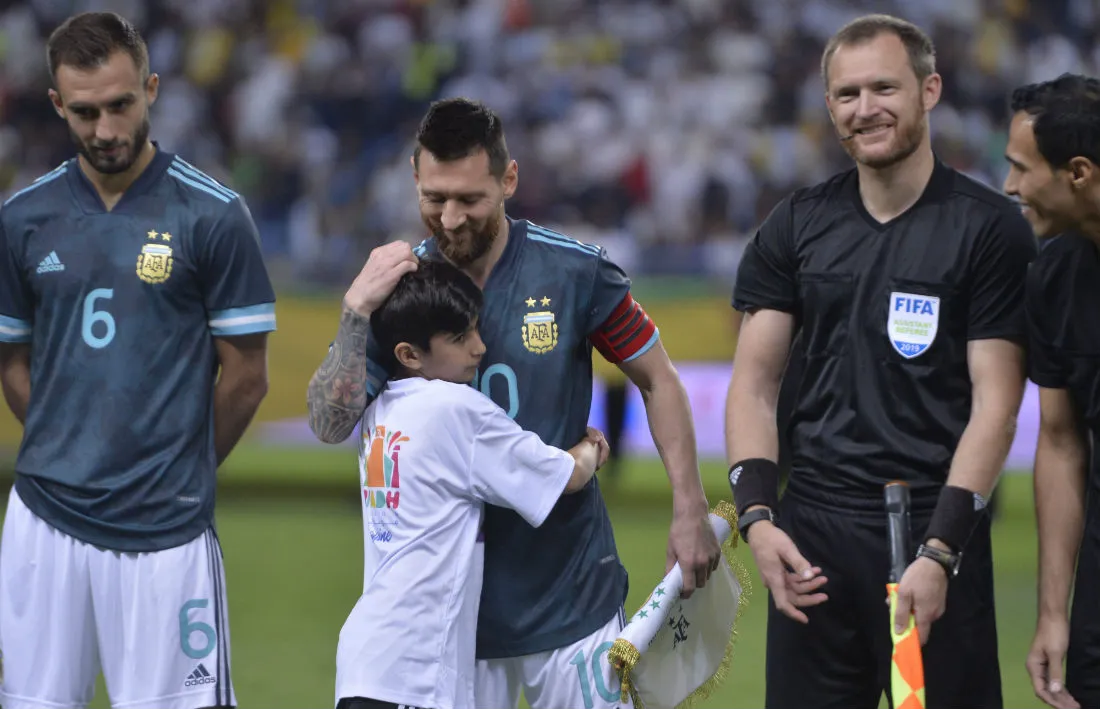 AP Lionel Messi abrazando a un niño previo al partido entre Argentina y Brasil