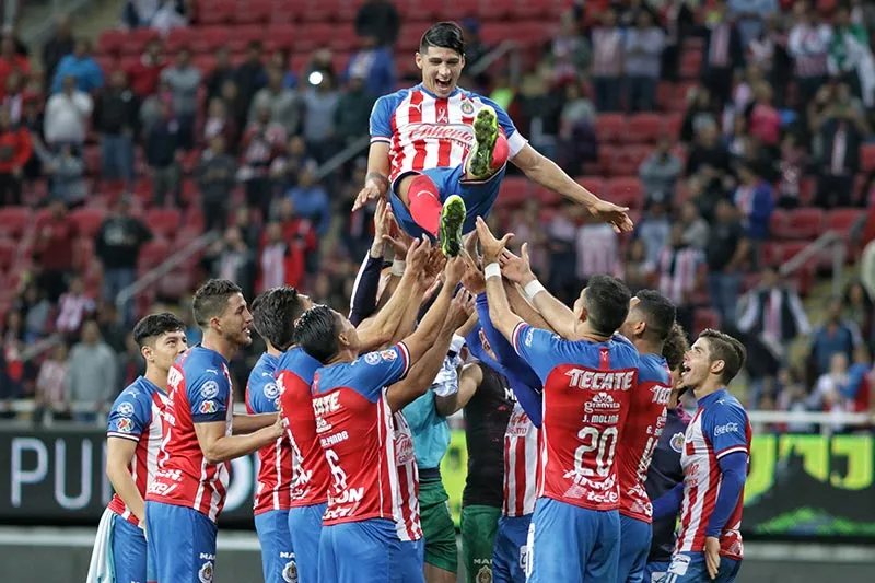 Alan Pulido es lanzado a los aires por sus compañeros