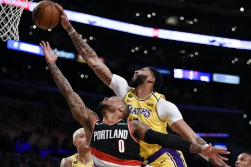 Damian Lillard intenta encestar sobre Anthony Davis