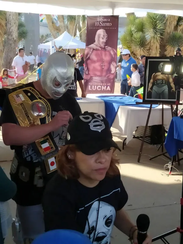 Imitador del Hijo del Santo firmando a fanáticos