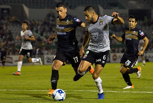 Jugadores de Leones Negros y Cafetaleros disputan un balón