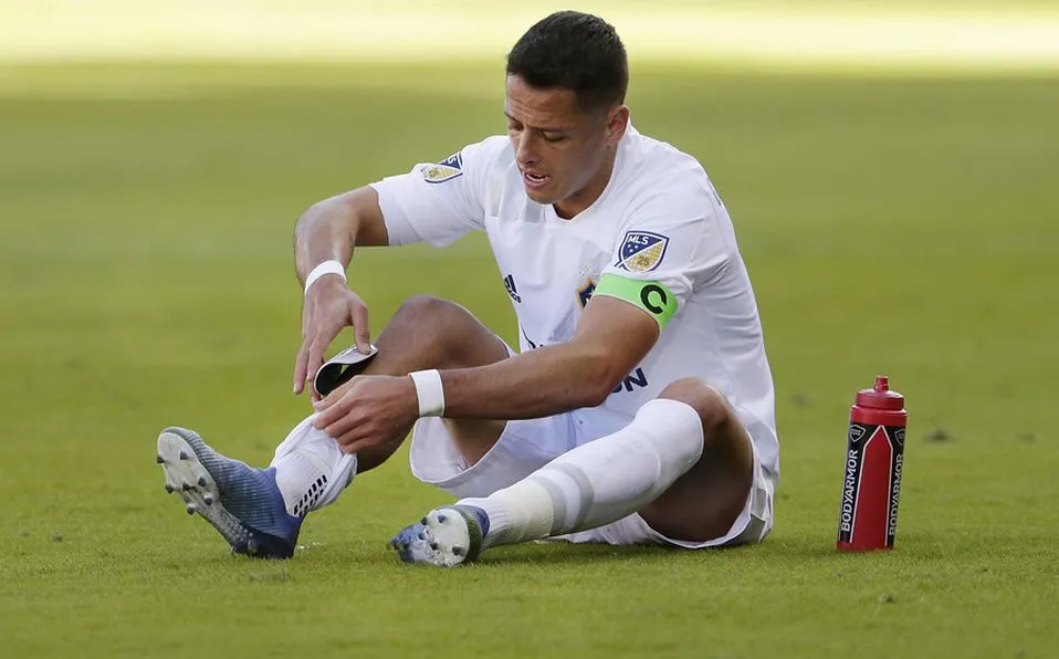 Chicharito se acomoda la espinillera durante un juego con Galaxy