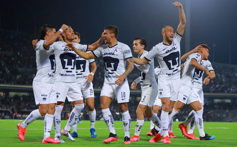 Jugadores de Pumas celebran una anotación en CU