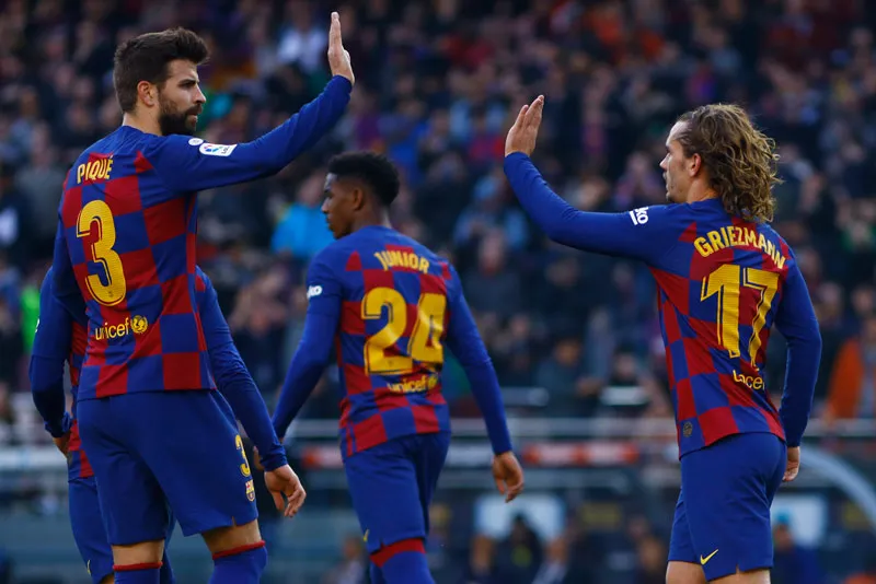 Piqué y Griezmann celebran un gol