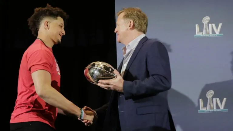 Patrick Mahomes recibe un premio de las manos de Roger Goodell