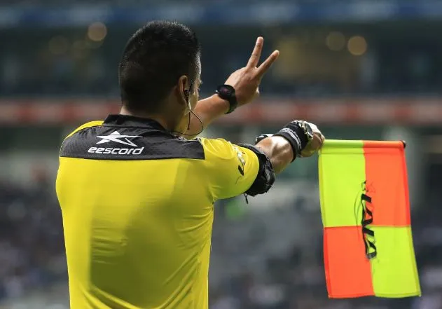 Asistente levanta el banderín en un juego