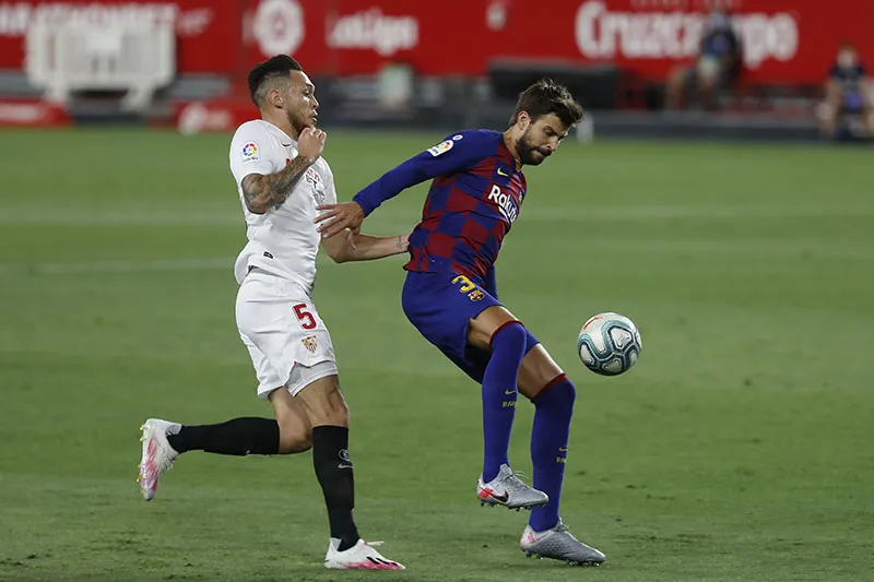AP Piqué pelea un balón con Ocampos en el Sevilla-Barcelona