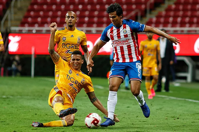 Macías disputa el balón con Meza